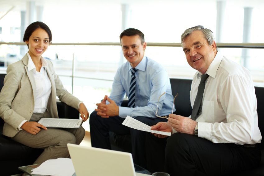 Portrait of happy team looking at camera at workplace