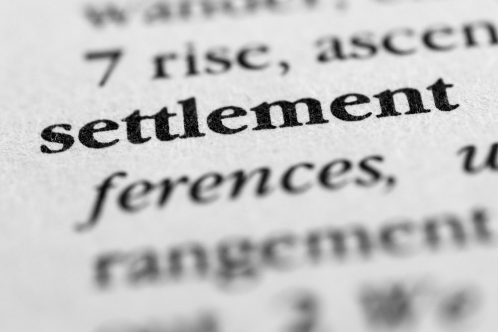 Close-up on print page, the word "Settlement" is in focus